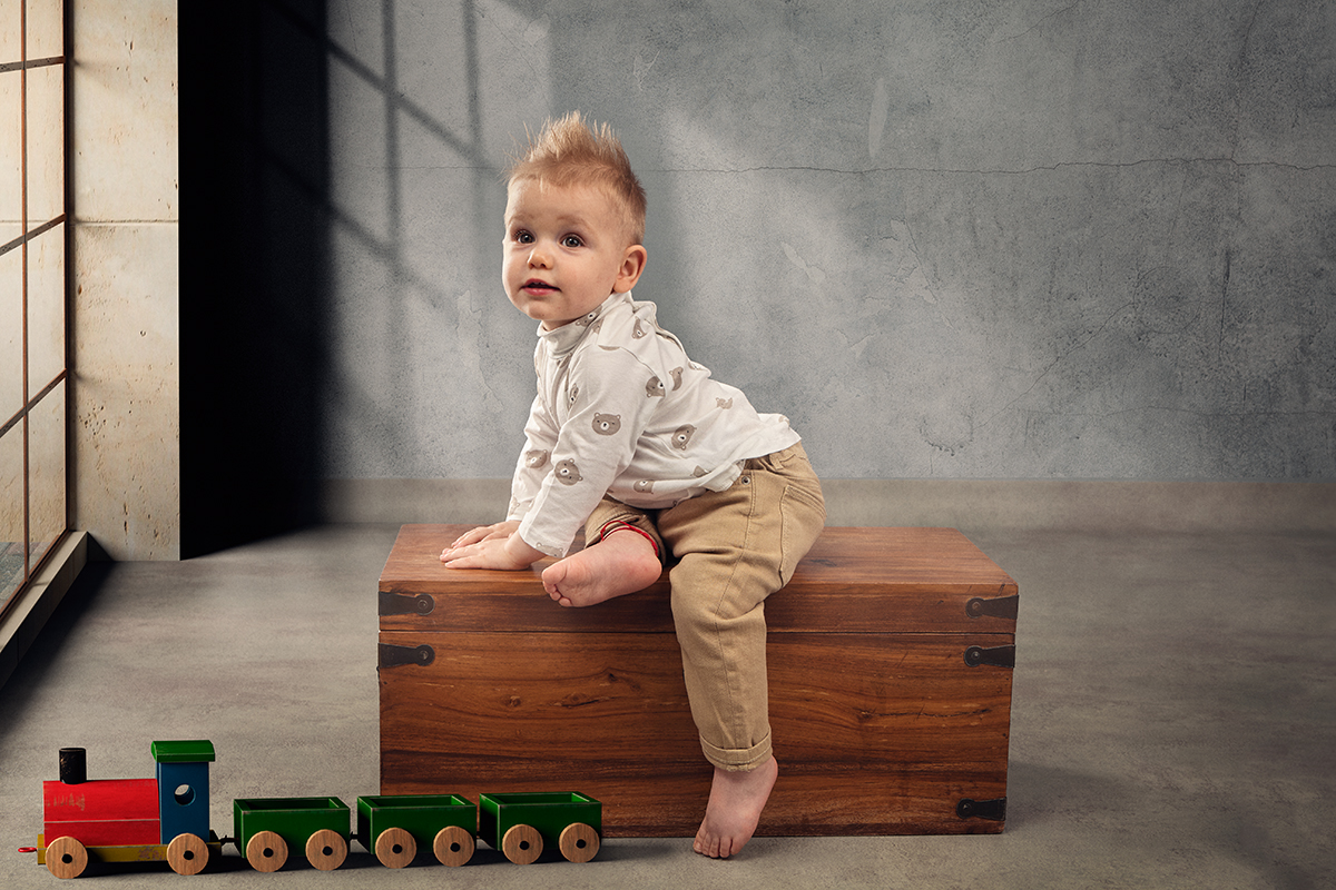 foto infantil de un niño sentado en un baúl realizada por Digilab en Badalona