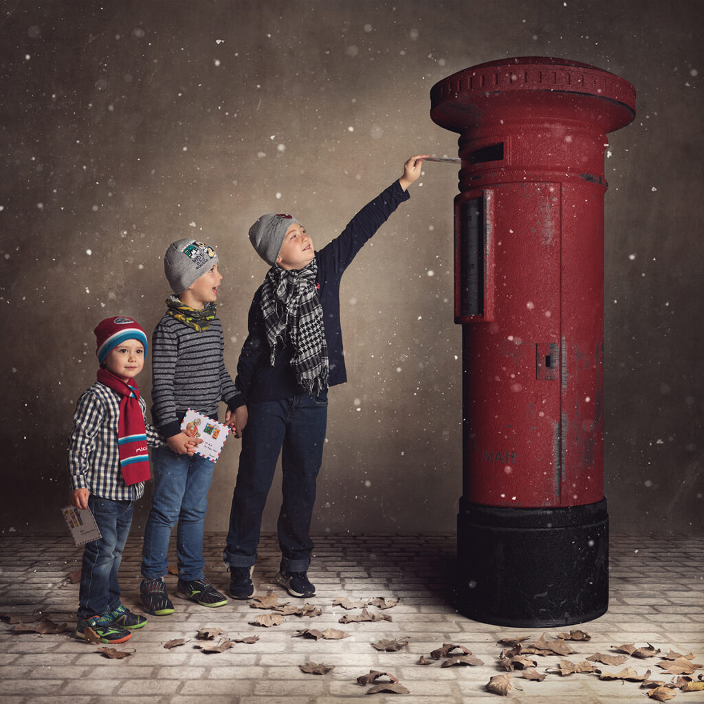 fotografía de navidad en Badalona, niños enviando carta en un buzón rojo.