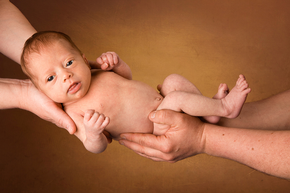 foto de un recién nacido cogido por los brazos de sus padres por Digilab en Badalona